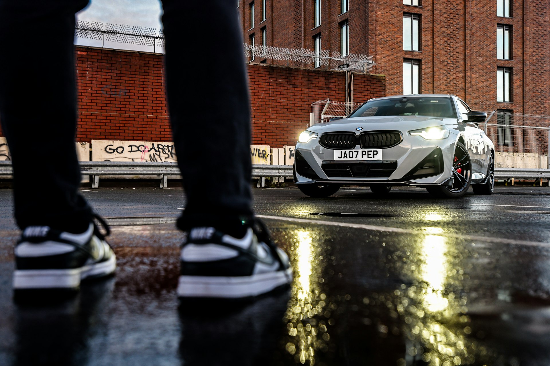 a person standing in front of a white car